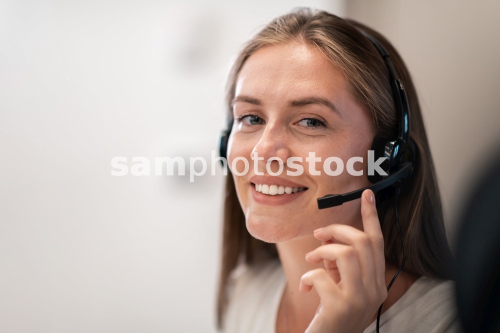 Helpline female operator with headphones in a call center.Business woman with headsets working in a call center. Selective focus. High-quality photo. Helpline female operator with headphones in call centre.Business woman with headsets working in a call center. Selective focus